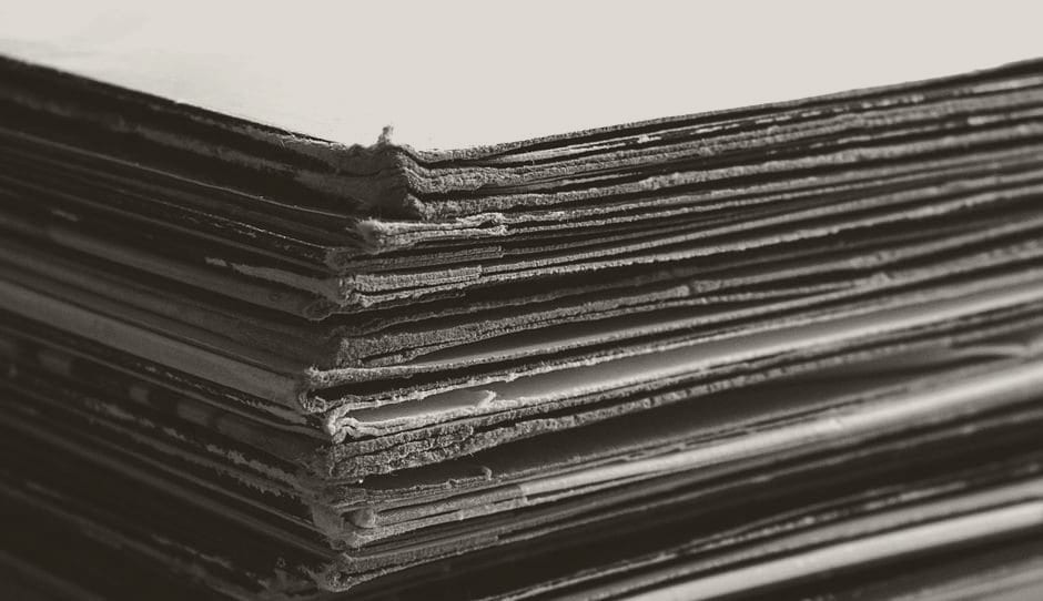 The stacked edges of a thick pile of aged paper documents